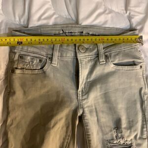 American Eagle Size 00 Super Strechy off white Jeans. Lots of Holes